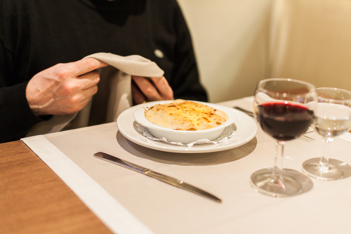 Canelones con una copa de vino y una copa de agua